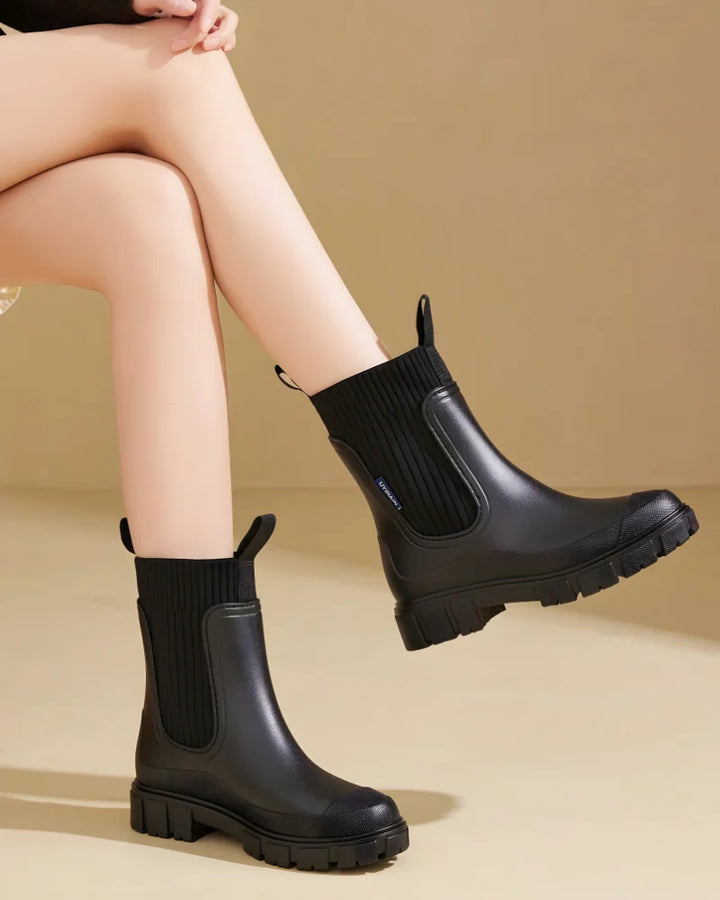 Black Women's Waterproof Chelsea Boots with Knit Ankle Cuff & Pull Tabs — Siobhan - Seated Legs Crossed