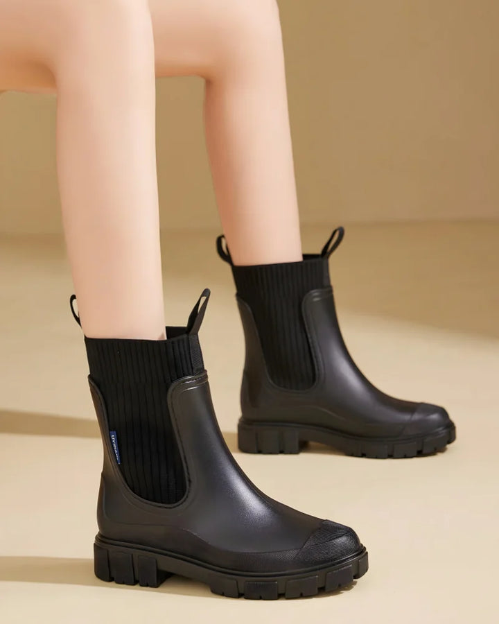 Black Women's Waterproof Chelsea Boots with Knit Ankle Cuff & Pull Tabs - Worn Perched Edge